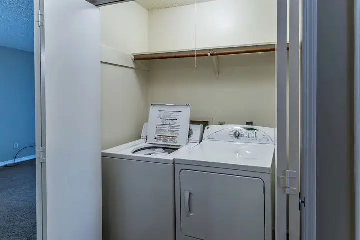 Laundry closet with washer and dryer units.